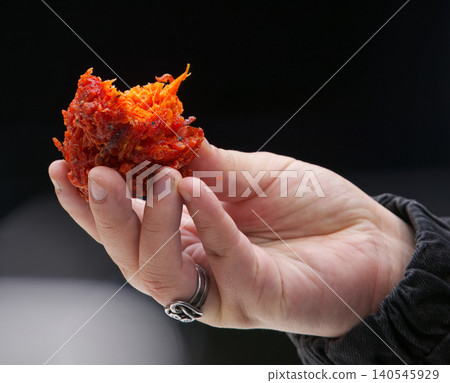 Hand holding bitten Onion Bhaji at Asia street food market in Karlin Hand holding bitten Onion Bhaji at Asia street food market in Karlin 140545929