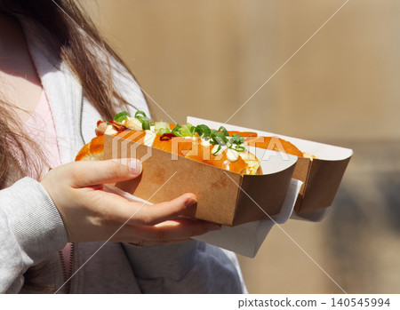 Woman holding loaded brioche buns at street food festival in karlin Woman holding loaded brioche buns at street food festival in karlin 140545994