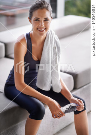 Fitness, water and towel with portrait of woman at home for health, wellness or workout. Exercise, smile and training with happy young athlete person satisfied in performance, progress or wellbeing Fitness, water and towel with portrait of woman at home for health, wellness or workout. Exercise, smile and training with happy young athlete person satisfied in performance, progress or wellbeing 140546014