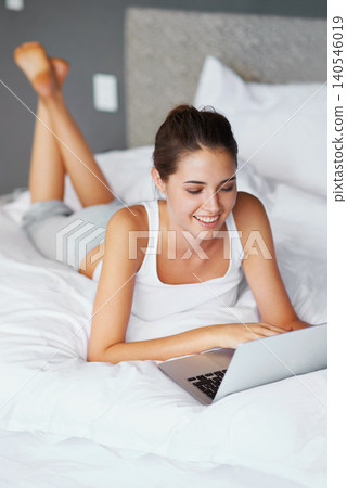 Woman, lying and laptop with smile in bed for connection, typing and chatting to friends, Female person, technology and computer for conversation in casual outfit, and comfortable in bedroom or home Woman, lying and laptop with smile in bed for connection, typing and chatting to friends, Female person, technology and computer for conversation in casual outfit, and comfortable in bedroom or home 140546019