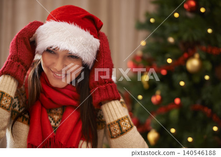 Christmas, face or smile and woman in home living room with red Santa hat, scarf and gloves for winter. Celebration, December and festive with happy young person in apartment for holiday season Christmas, face or smile and woman in home living room with red Santa hat, scarf and gloves for winter. Celebration, December and festive with happy young person in apartment for holiday season 140546188