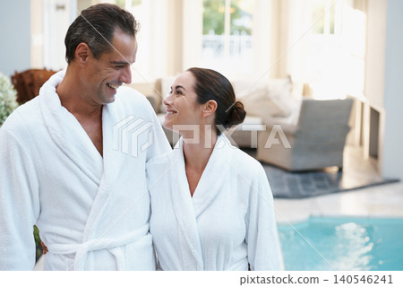 Holiday, robe and couple at hotel pool with smile, embrace and relax together at wellness spa getaway. Hospitality, happy woman and man at luxury villa for travel, vacation and love on romantic date Holiday, robe and couple at hotel pool with smile, embrace and relax together at wellness spa getaway. Hospitality, happy woman and man at luxury villa for travel, vacation and love on romantic date 140546241