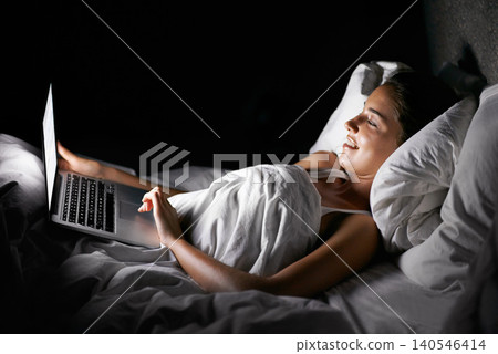 Bedroom, laptop and night with woman streaming content, video or browsing social media in dark home. Bed, computer and subscription with young person in apartment to relax on weekend time off Bedroom, laptop and night with woman streaming content, video or browsing social media in dark home. Bed, computer and subscription with young person in apartment to relax on weekend time off 140546414