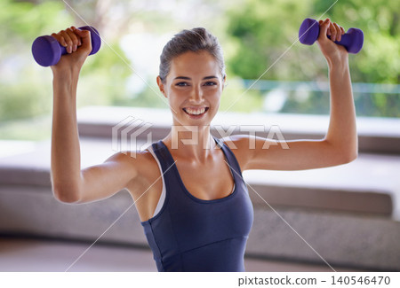 Portrait, fitness and weight lifting with sporty woman at gym for health or wellness workout. Exercise, training and dumbbells with happy young person satisfied with performance progress or wellbeing Portrait, fitness and weight lifting with sporty woman at gym for health or wellness workout. Exercise, training and dumbbells with happy young person satisfied with performance progress or wellbeing 140546470