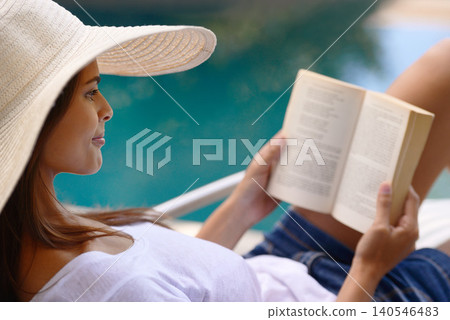 Vacation, relax and woman at pool with book, hat and lounge with happy summer travel on hotel patio. Holiday, deck chair and girl with smile, reading and story with sunshine, weekend or luxury resort Vacation, relax and woman at pool with book, hat and lounge with happy summer travel on hotel patio. Holiday, deck chair and girl with smile, reading and story with sunshine, weekend or luxury resort 140546483