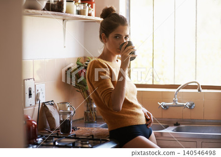 Portrait, woman and drinking coffee in home kitchen to relax, peace or calm for energy at breakfast in the morning. Serious, tea cup and young person with latte, espresso or hot beverage in apartment Portrait, woman and drinking coffee in home kitchen to relax, peace or calm for energy at breakfast in the morning. Serious, tea cup and young person with latte, espresso or hot beverage in apartment 140546498