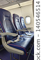Vertical view of interior view of a passenger airplane cabin showcasing blue seats arranged in rows. Highlights air travel comfort, modern design, and in-flight experience. 140546514