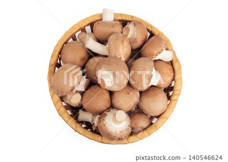 Brown champignon mushroom a wicker basket isolated on white background. Top view. Flat lay Brown champignon mushroom a wicker basket isolated on white background. Top view. Flat lay 140546624
