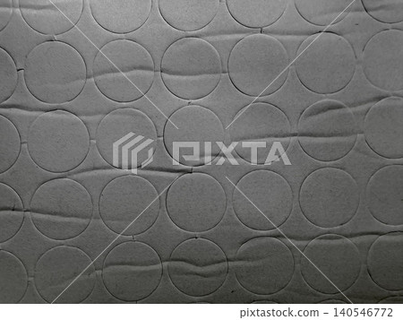 monochromatic geometric pattern of circular paper stickers on textured gray cardboard background 140546772
