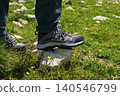 Hiking boots firmly stepping onto a rock in the Austrian Alps, highlighting connection with nature through physical activity 140546799