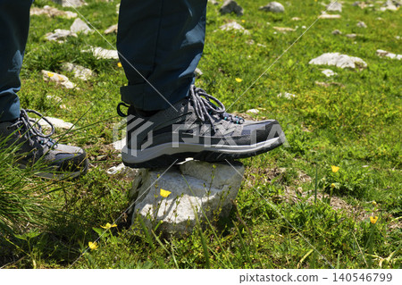 Hiking boots firmly stepping onto a rock in the Austrian Alps, highlighting connection with nature through physical activity Hiking boots firmly stepping onto a rock in the Austrian Alps, highlighting connection with nature through physical activity 140546799