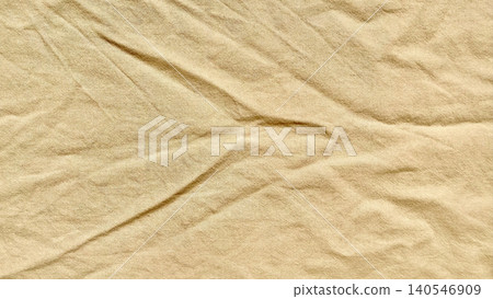 crumpled beige linen fabric creates abstract shadows in a minimal sustainable textile background 140546909