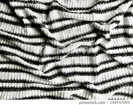 crumpled monochrome striped knit fabric reveals organic shadows and tactile woven texture in this moody macro still life 140547005