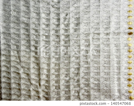 waffle weave cotton fabric background with elegant gold embroidery showcases sustainable textile texture waffle weave cotton fabric background with elegant gold embroidery showcases sustainable textile texture 140547068