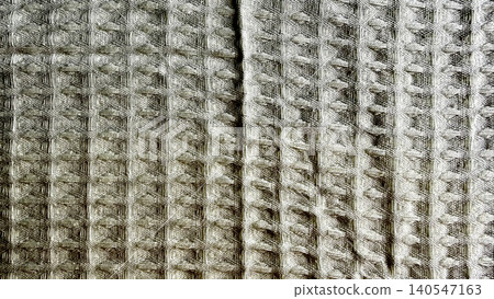 natural stone-grey waffle-weave cotton texture fabric, close-up shot capturing intricate tactile geometric pattern and artisan quality detail, evoking comfort, sustainability natural stone-grey waffle-weave cotton texture fabric, close-up shot capturing intricate tactile geometric pattern and artisan quality detail, evoking comfort, sustainability 140547163