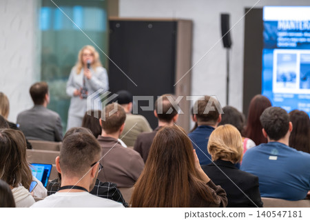 Business speaker presenting to audience at conference, attendees listening in modern meeting room 140547181