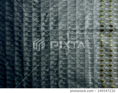 luxurious ribbed fabric texture shifts from dark weave to shimmering golden metallic accents in intricate detail luxurious ribbed fabric texture shifts from dark weave to shimmering golden metallic accents in intricate detail 140547210