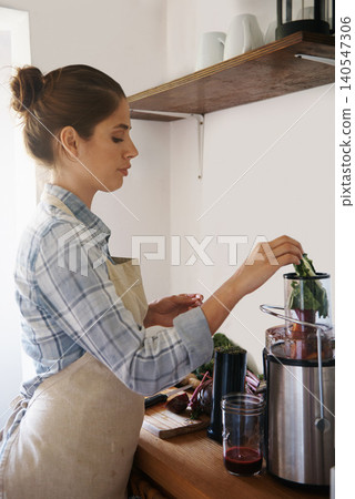 Vegetables, fruit and woman with blender for smoothie in morning at cafe or prepare juice with kale. Breakfast, nutrition and person mixing healthy protein shake in kitchen with machine for diet 140547306