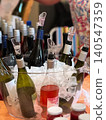 Wine bottles chill in ice bucket with pour spouts, showing wine service for tasting event and reception. Beverage catering, bar station, celebration drink, and hospitality service 140547359