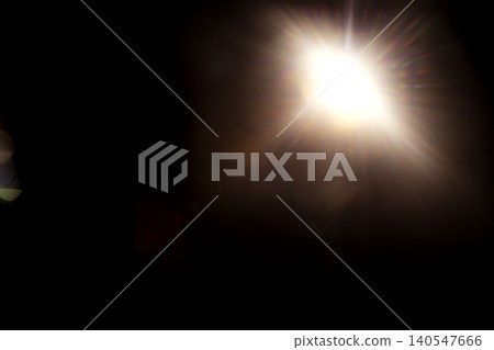 Bright light source emitting rays in a dark environment, creating a dramatic contrast with surrounding shadows and highlighting the edges of nearby objects 140547666