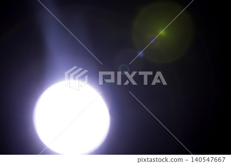 Bright circular light source emitting beams and lens flares against a dark background, creating a dramatic visual effect with varying light intensity and color Bright circular light source emitting beams and lens flares against a dark background, creating a dramatic visual effect with varying light intensity and color 140547667