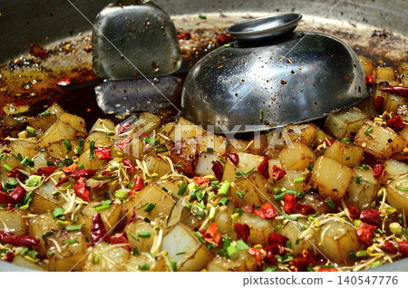Spicy fried potatoes cooking in a large pan Spicy fried potatoes cooking in a large pan 140547776