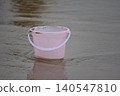 Pink bucket on wet beach sand 140547810