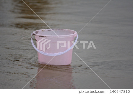 Pink bucket on wet beach sand Pink bucket on wet beach sand 140547810