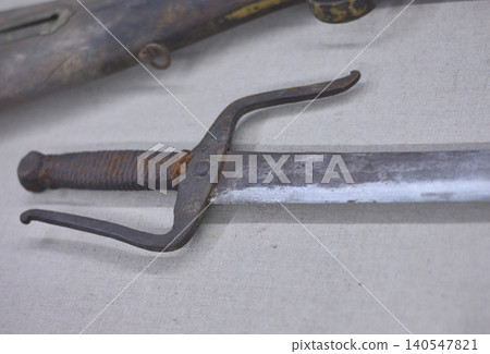 Old sword with worn handle on fabric 140547821