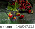 Freshly picked organic strawberries with green leaves and rustic pitcher 140547838