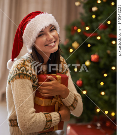 Christmas, happy and portrait of woman with present at her home for festive celebration, event or party. Smile, face and female person with gift box for xmas surprise in living room at apartment. Christmas, happy and portrait of woman with present at her home for festive celebration, event or party. Smile, face and female person with gift box for xmas surprise in living room at apartment. 140548223