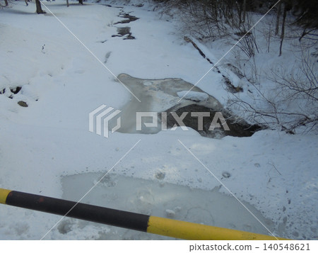 Partially frozen Ostravice river flowing from under bridge through bushy area. Partially frozen Ostravice river flowing from under bridge through bushy area. 140548621