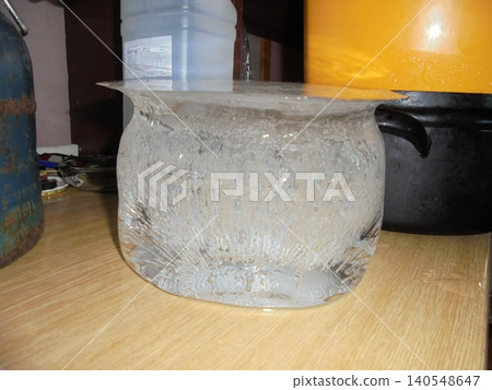 Bucket-shaped ice with crystallic structures inside standing on a kitchen unit Bucket-shaped ice with crystallic structures inside standing on a kitchen unit 140548647