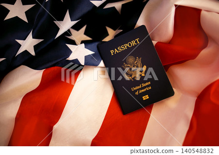 Passport of the United States of America placed on an American flag with red and white stripes and blue field featuring white stars in a close-up view Passport of the United States of America placed on an American flag with red and white stripes and blue field featuring white stars in a close-up view 140548832