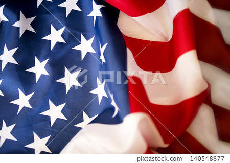 American flag with red and white stripes and blue field featuring white stars, fabric texture visible, symbolizing patriotism and national identity 140548877