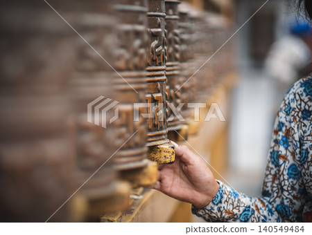 Pilgrim Spins Prayer Wheels in Kathmandu Pilgrim Spins Prayer Wheels in Kathmandu 140549484