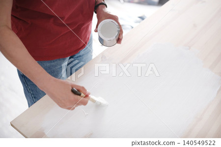 Woman Painting Wooden Surface With Paint Table Using A Brush 140549522