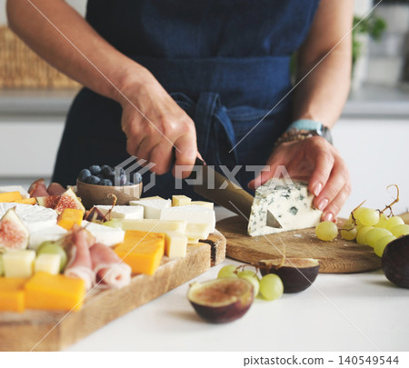 Woman Preparing A Cheese Platter Cutting Blue Cheese With Mold 140549544