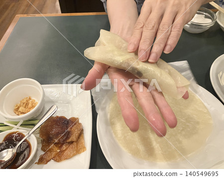 A woman's hands wrapping Peking duck A woman's hands wrapping Peking duck 140549695