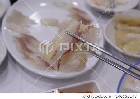 Chopsticks Holding Delicate Seafood Slices 140550172