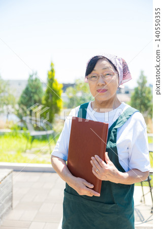 Senior working at an open-air cafe Senior working at an open-air cafe 140550355
