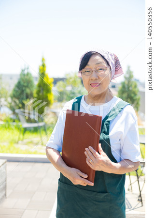 Senior working at an open-air cafe Senior working at an open-air cafe 140550356
