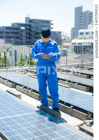 老年人在辦公大樓屋頂檢查太陽能板 老年人在辦公大樓屋頂檢查太陽能板 140550433
