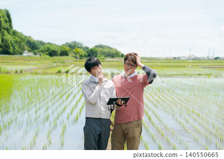 Farmers standing along the field path Farmers standing along the field path 140550665