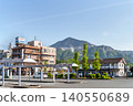 A stately wooden tourist information center stands in the plaza in front of Seibu Chichibu Station, with the Chichibu mountain range in the background (Chichibu City, Saitama Prefecture). 140550689