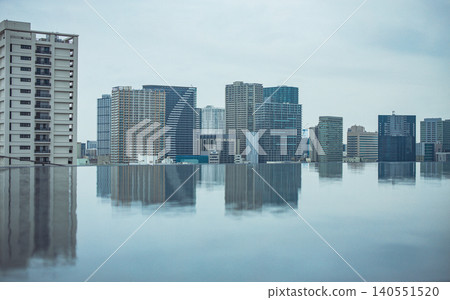 Overcast sky; high-rise buildings reflected in the water basin in Takanawa; urban landscape. Overcast sky; high-rise buildings reflected in the water basin in Takanawa; urban landscape. 140551520