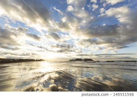 A view of Shonan Kugenuma Beach, where Enoshima Island and the sunrise sky are reflected. A view of Shonan Kugenuma Beach, where Enoshima Island and the sunrise sky are reflected. 140551598