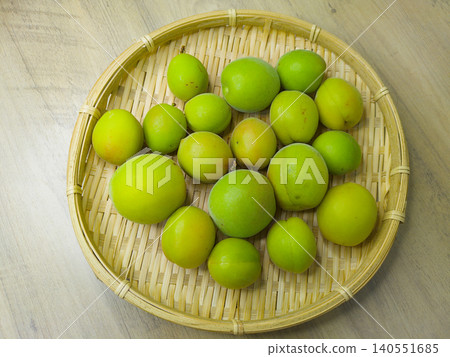 Image of harvesting green plums arranged on a bamboo basket. Image of harvesting green plums arranged on a bamboo basket. 140551685