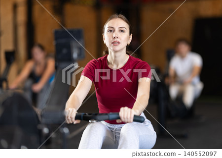 Woman exercising on a rowing machine 140552097