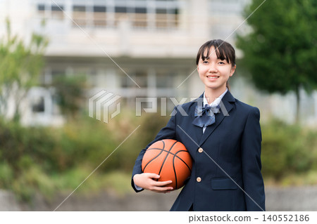 穿著校服的高中、國中和小學女生站在校園裡,手裡拿著籃球 穿著校服的高中、國中和小學女生站在校園裡,手裡拿著籃球 140552186